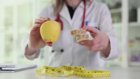 nutritionist comparing healthy apple with a sweet treat