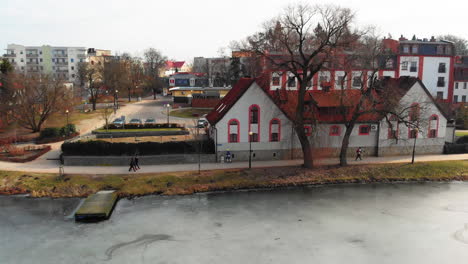 blue dressed person on the frozen lake running path in the middle of the town