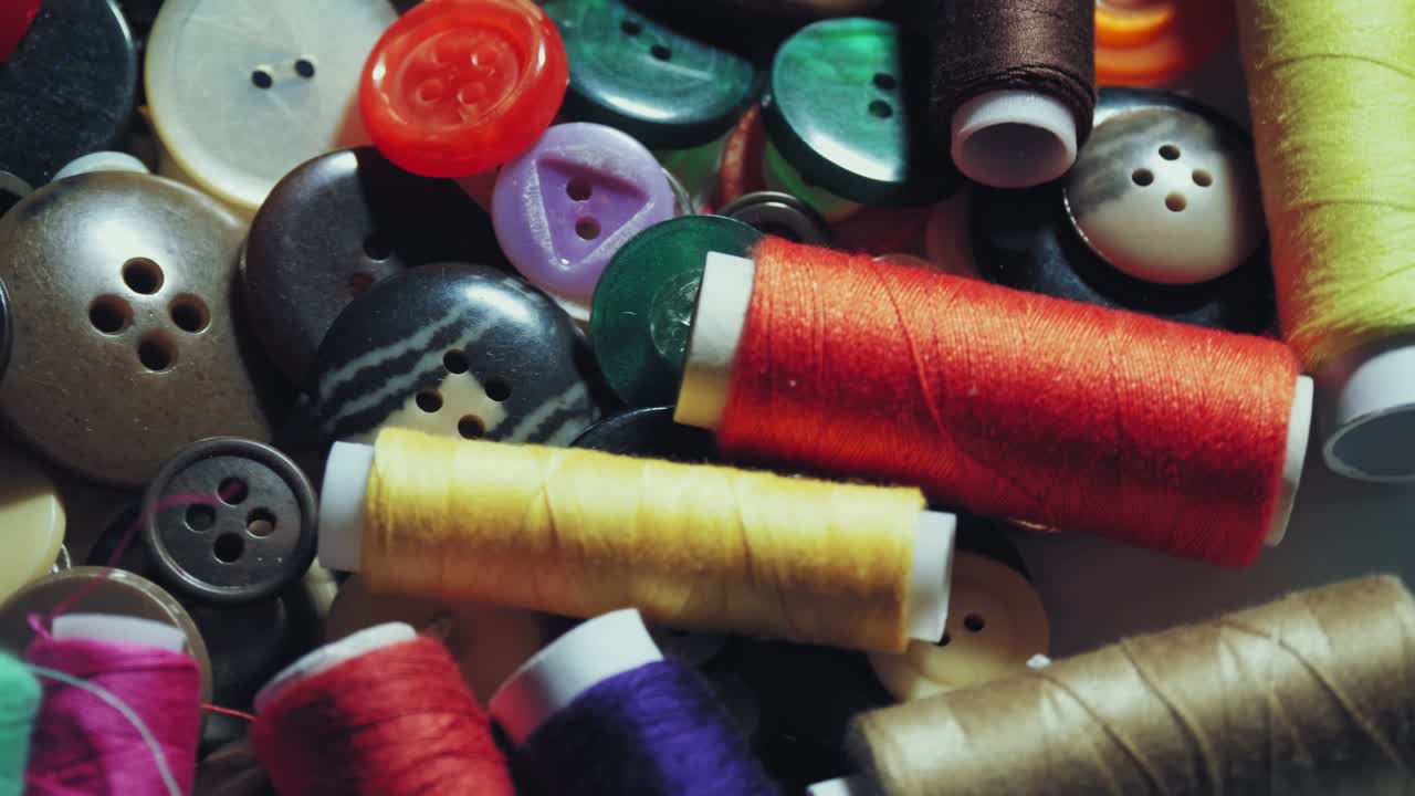 bottoni da cucire. close-up. rotazione. vari bottoni dacuci colorati rotano sul giradischi. sfondo di movimento a ciclo. concetto di colore, moda, sartoria, cucito, sarto
