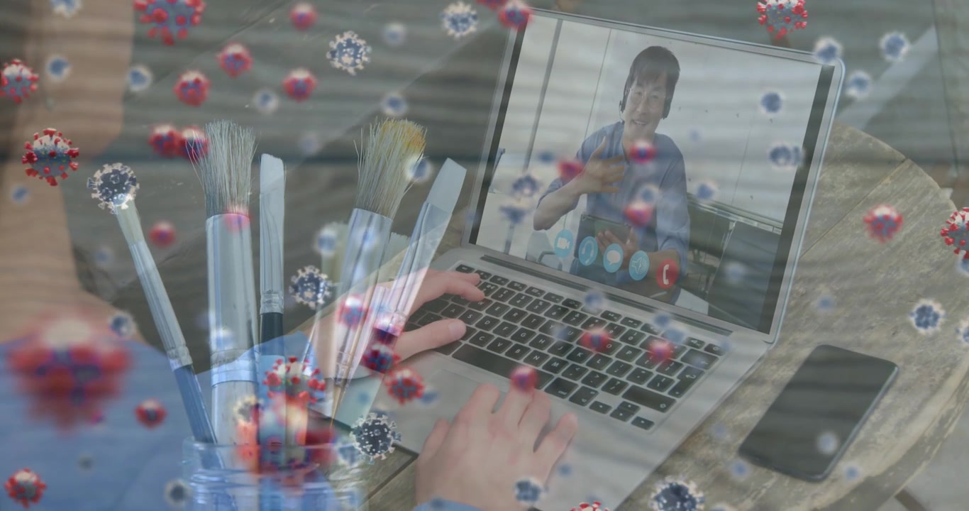 Animation af virusceller over glad asiatisk mand, der har et videoopkald på bærbar computer