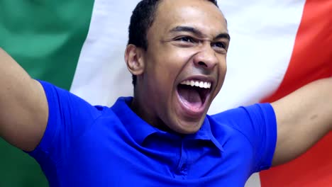 italian fan celebrating while holding flag of italy in slow motion