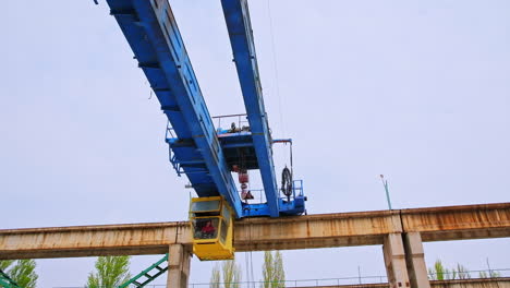 automated crane machine for lifting and transporting materials. worker sitting in the booth and operating the technique.