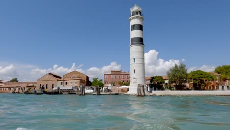 Mit-Einem-Boot-Am-Wunderschönen-Leuchtturm-Von-Murano-Vorbeifahren