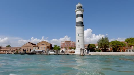 pasando el hermoso faro de murano en un barco