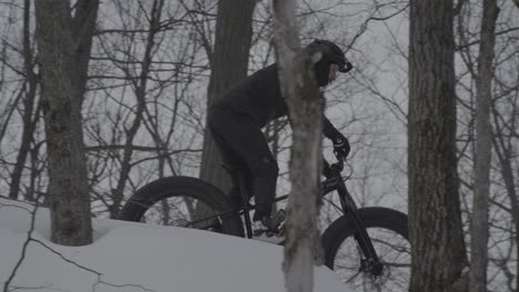 fatbike cyclist riding down a forest trail