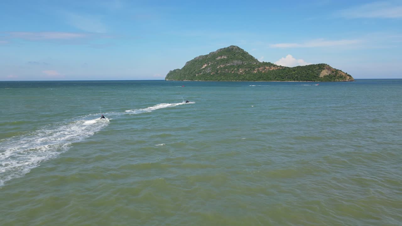 섬을 향해 왼쪽에 있는 두 대의 제트 스키를 따라가는 공중 영상