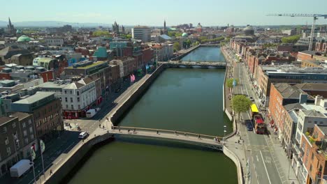 side-on aerial video of the river liffey, various bridges and dublin city centre in dublin, ireland on a bright and sunny day. filmed in 4k, 60fps and with rec709 color.
