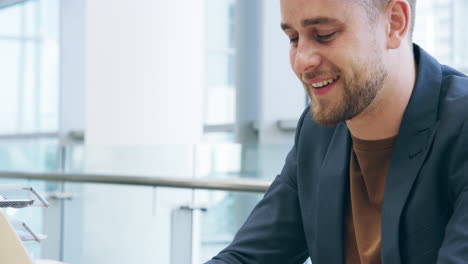 Ein-Hübscher-Junger-Geschäftsmann,-Der-An-Seinem-Laptop-Arbeitet