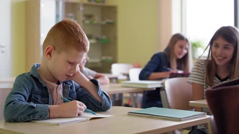 video de un niño triste sentado burlado en la clase