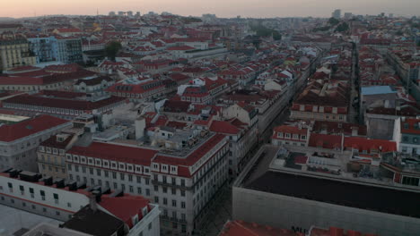 Vista-Aérea-De-Tejados-Rojos-De-Casas-Coloridas-En-El-Centro-De-La-Ciudad-De-Lisboa-Y-Monumento-Arco-Da-Rua-Augusta-En-La-Ciudad-Europea-Tradicional