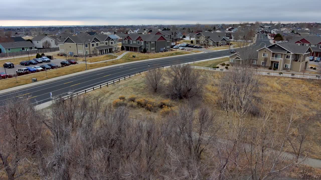 A unique drone shot flys through a gazebo and over trees to reveal the neighborhood surrounding and urban park. Greeley Colorado winter.