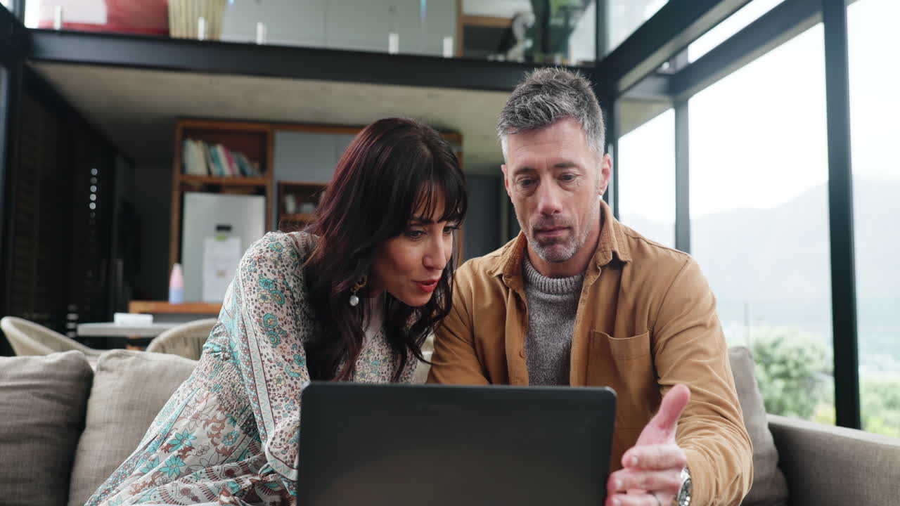 Couple Discussing and Collaborating on Laptop in Modern Home