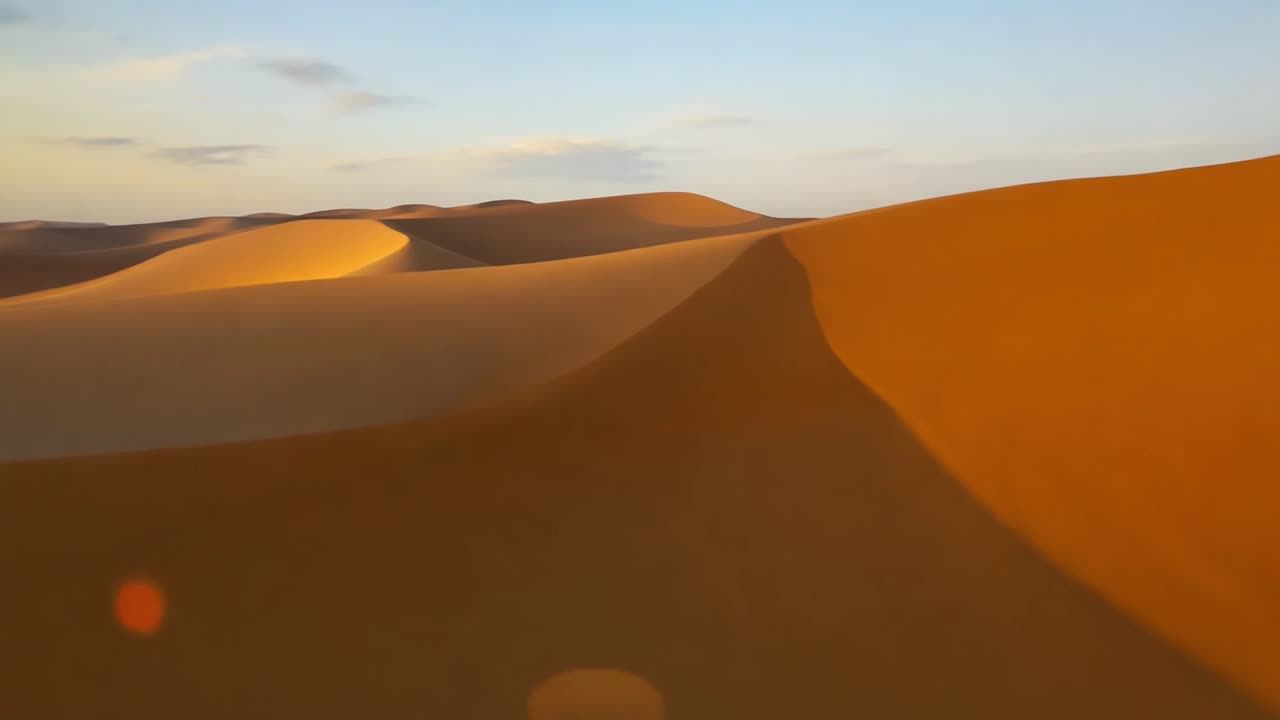 el viento barre el desierto del sáhara, dando forma a las dunas de arena dorada bajo un cielo brillante y soleado.