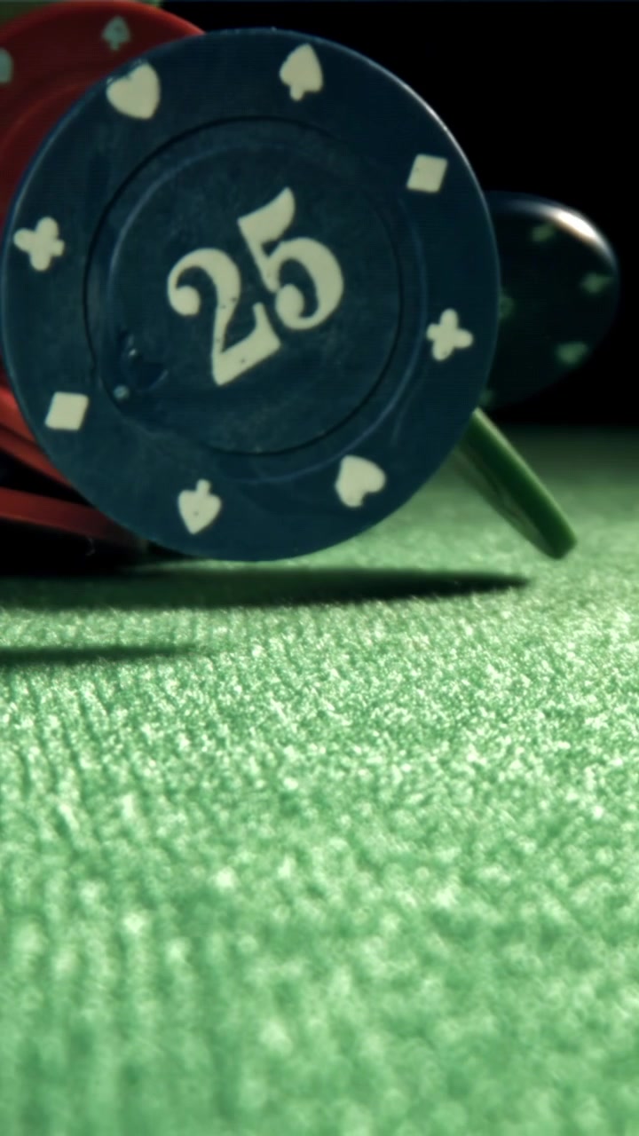 Fiches da casinò che cadono e si disperdono su un tavolo di feltro verde