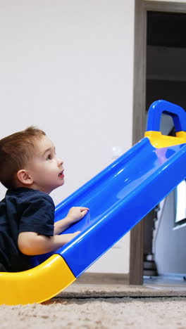 colorful kindergarten active play. sliding playground small boy. vertical video