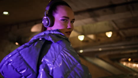 woman enjoy music walking evening subway closeup. girl listening song in headset