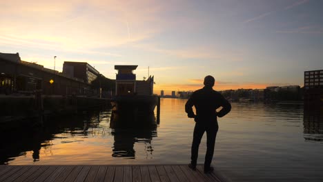 young man walking out to the edge of a pier and taking in the view during a majestic sunset
