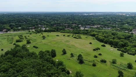 aerial forward dolly shot over beautiful green rural landscape on cloudy day, panoramic view