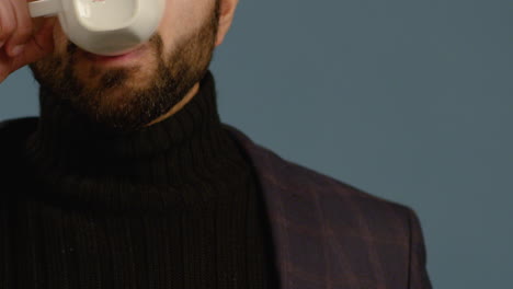 cu young man drinks from a mug