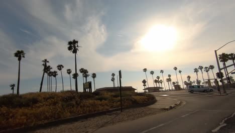 sunset drive down pacific coast hwy passing palm trees and shore line on the huntington beach coast