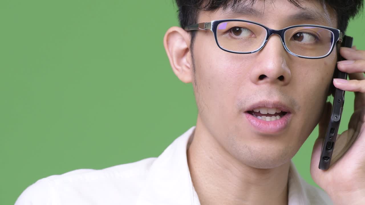 젊은 아시아 사업가 가 전화 를 하면서 생각 하고 있다