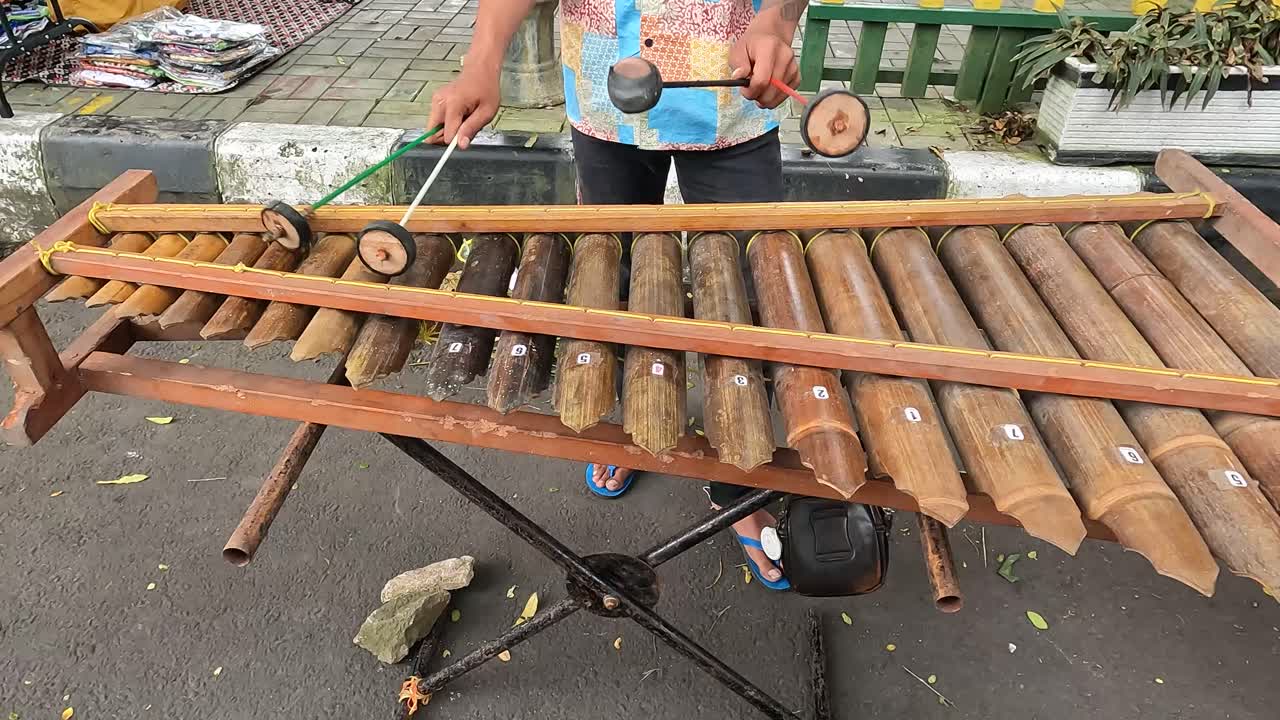 Unrecognizable musician plays Indonesian instrument Kulintang, no face