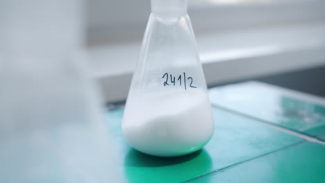 Test-tubes-with-white-liquid-being-shaken-in-a-chemistry-laboratory