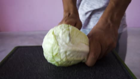 joven cortando repollo para ensalada