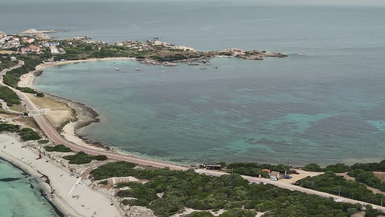 Vista della costa sarda con spiaggia, acqua ed edifici in una giornata di sole
