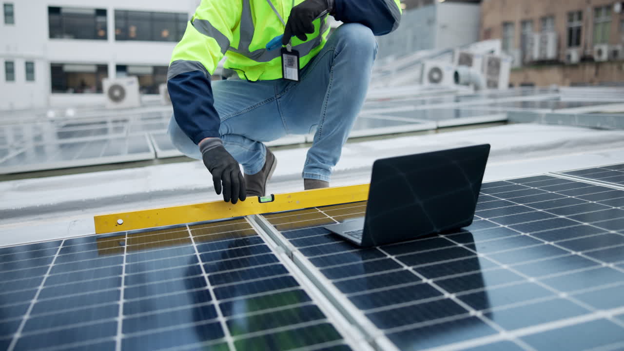 Solar panel installation by worker with laptop