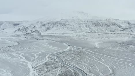 follow frozen river stream near langjokull glaciar iceland aerial drone