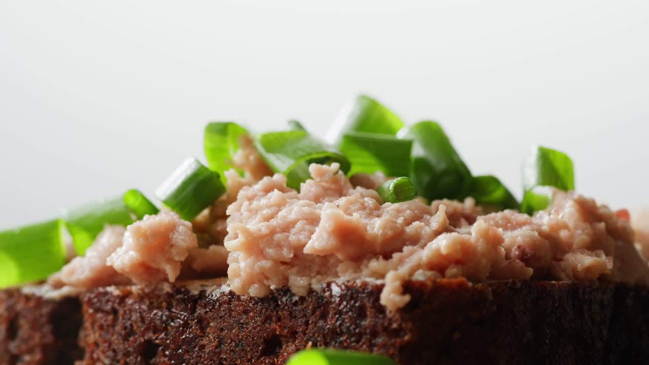 Smoked cod liver in oil in open tin can with fresh greens on wooden table. Seafoods delicacy. High quality 4k footage