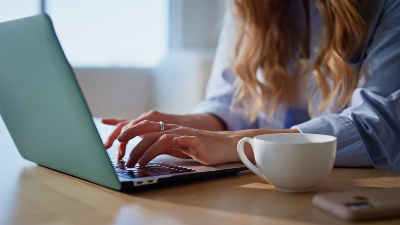 Closeup hands typing laptop keyboard on kitchen countertop. Remote woman working
