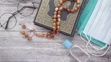 libro sagrado del corán, oraciones, cuentas de oración, desinfectante de manos y máscara en el suelo