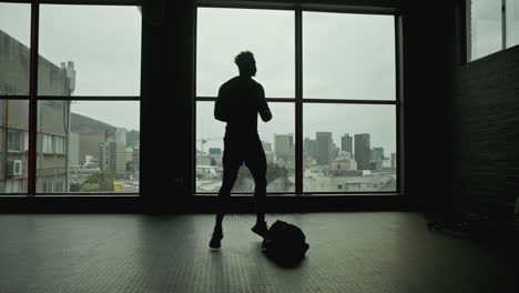 silhouette of a man in a gym overlooking the city