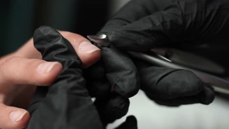 using small clippers to cut excess skin off the edges of a clients hand at a nail salon