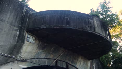 Tilting-down-close-up-of-front-of-Abandoned-World-War-II-Bunker-at-day