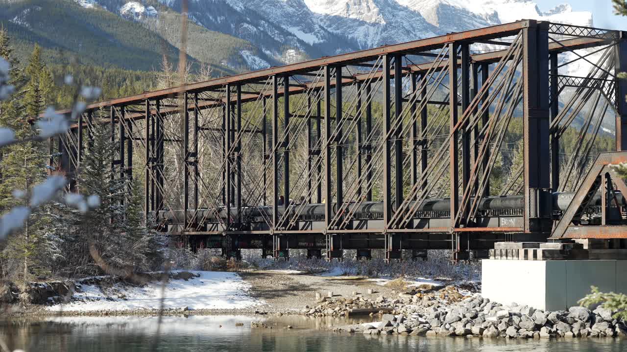 timelapse of people walking on the engine bridge in Canmore alberta. The bow river flows on by