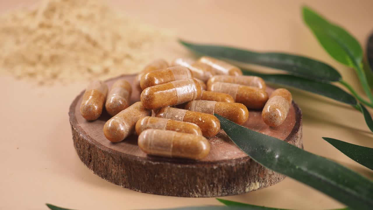 Natural Herbal Supplement Capsules on Wooden Coaster