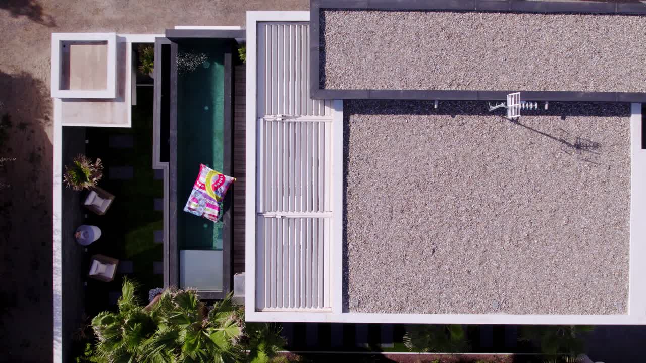 disparo de arriba hacia abajo por encima de una villa privada con una piscina en un balcón