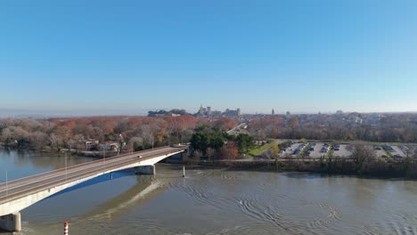 Aerial-orbiting-shot-of-cars-driving-over-a-bridge-to-Villeneuve-lès-Avignon