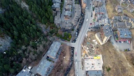 Drone-shot-pan-up-over-beautiful-small-town-in-between-mountainous-valley-winter