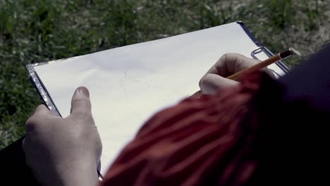 person drawing a sketch outdoors