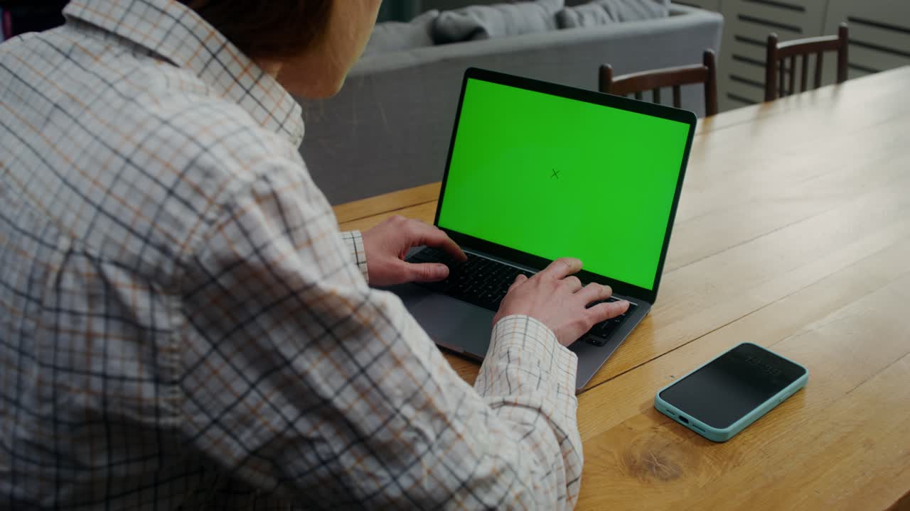 persona trabajando en una computadora portátil con una pantalla verde