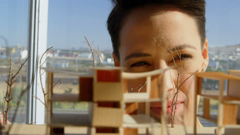 vista frontal de arquitectos mujeres caucásicas mirando el modelo de edificio en la oficina 4k