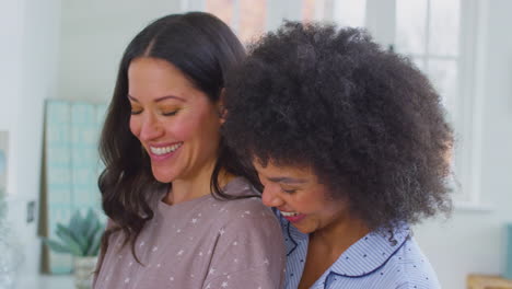 close up of pregnant same sex couple making breakfast in kitchen