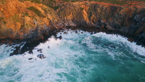 stormy waves crashing coastal rocks. aerial sea water breaking stone cliff coast