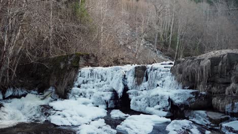 Water-Bursting-Out-Through-Snowy-Old-Dam-In-Early-Spring