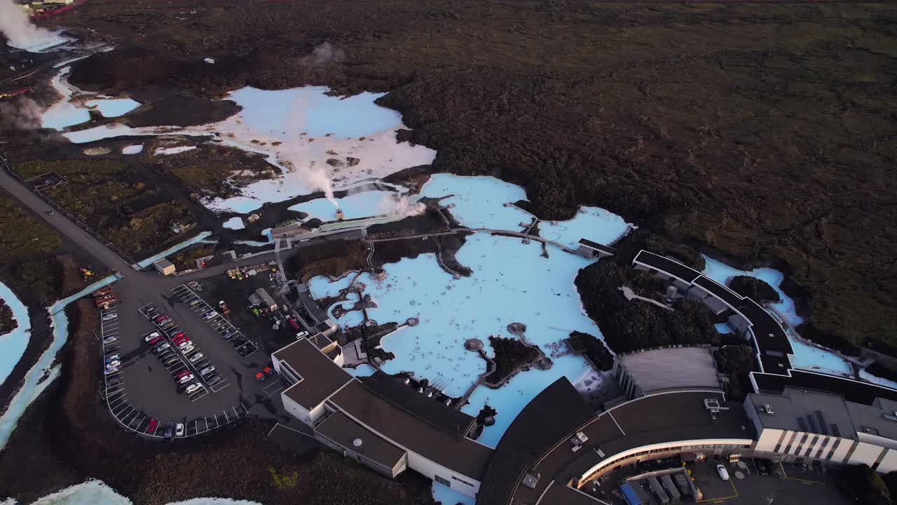 Many people taking a bath in Blue Lagoon geothermal spa at sunset time