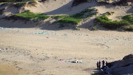 group of people cleaning plastic trash polluted beach on vietnam coast